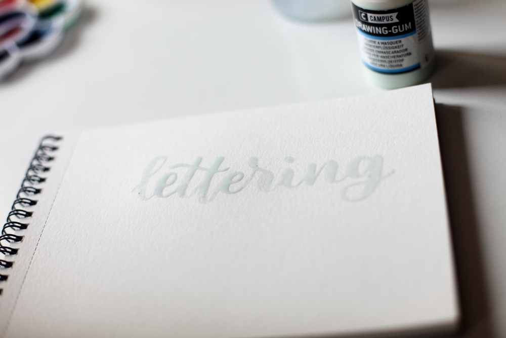 écrire avec le masking gum et un pinceau avec effet brushlettering